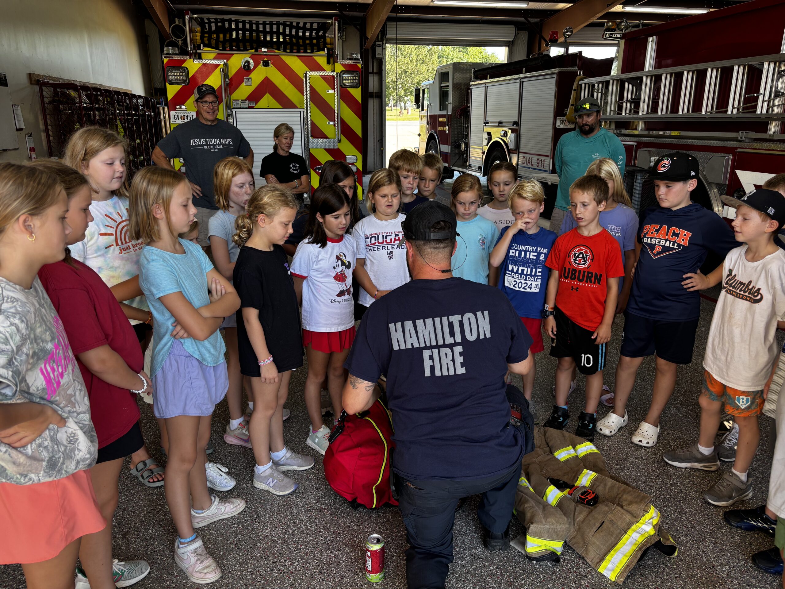 Children participating in a Mission and Art Camp visit with local firefighters